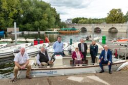 Open motorboat with a group of people, including two in wheelchairs, sitting in it.