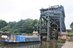 Boat waiting below a tall boat lift