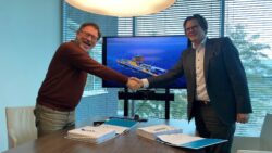 Two men shaking hands over a meeting room desk having finalised the agreement.