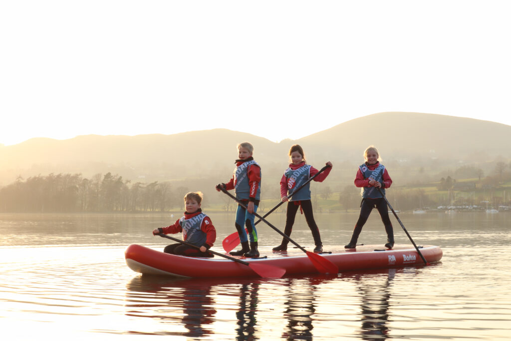 kids on a Barton Marine stand up paddle board at sunset