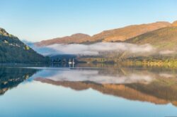 Large lake with mountainous backdrop and mist