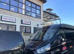Two black vans outside a wooden fronted building