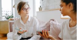 Two women in white shirts chatting
