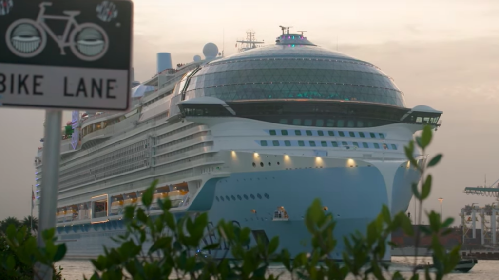 Icon of the Seas, biggest cruise ship in the world, pictured on river next to Bike Lane sign