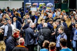 crowd of eager people looking at products in an exhibition