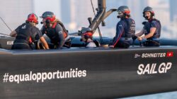 Group of four female sailors in SailGP boat.