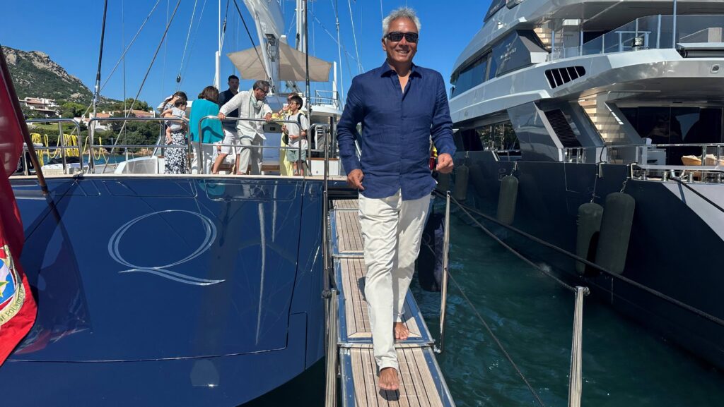 A man strolls on a pontoon next to a superyacht berthed in Japan