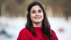 Journalist. Katy Stickland, in red jumper smiles at camera as she is appointed chair of YJA